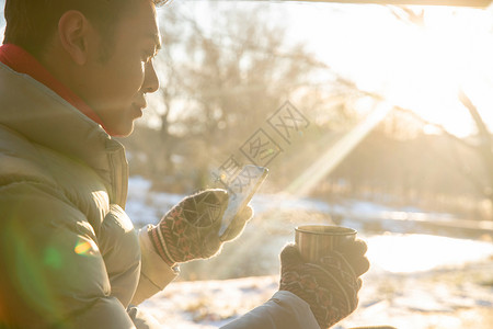 坐在雪地里看手机的男人高清图片