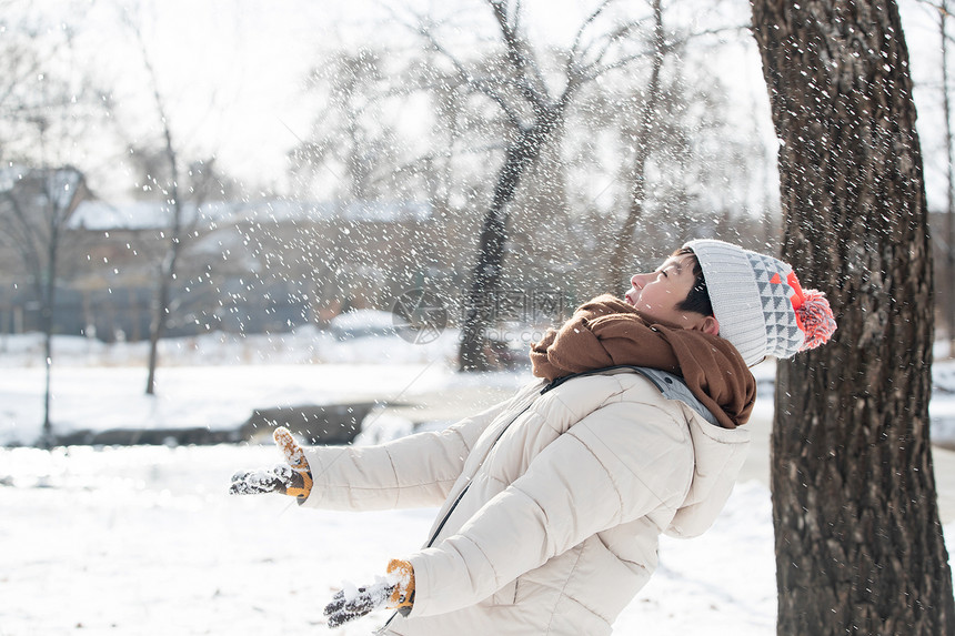 快乐的小男孩在雪地里玩耍图片