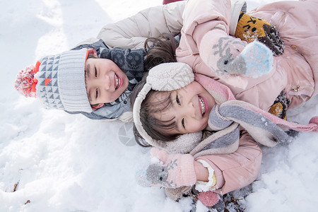 躺在雪地里两个小朋友在雪地里玩耍背景