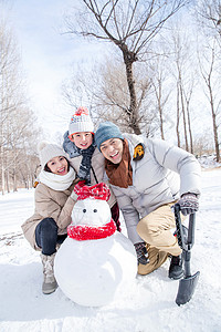 三个雪人一家三口在雪地里堆雪人背景