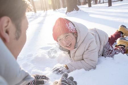 冬天打雪仗在雪地上玩耍的快乐父子背景