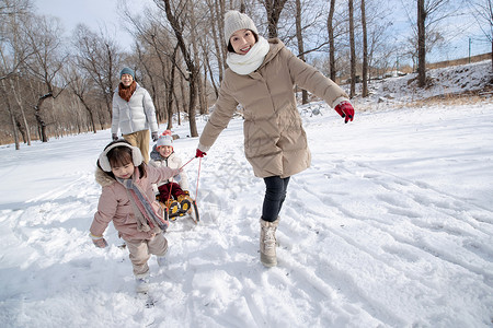 欢乐家庭在雪地上玩雪橇高清图片