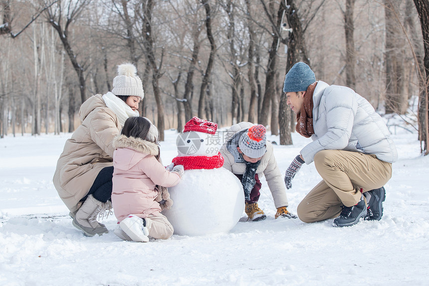 欢乐家庭在雪地里堆雪人图片