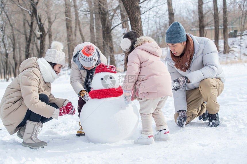 欢乐家庭在雪地里堆雪人图片