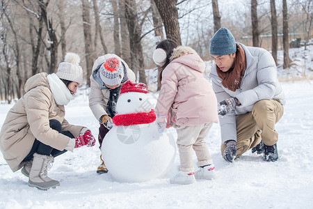 堆雪人男孩欢乐家庭在雪地里堆雪人背景