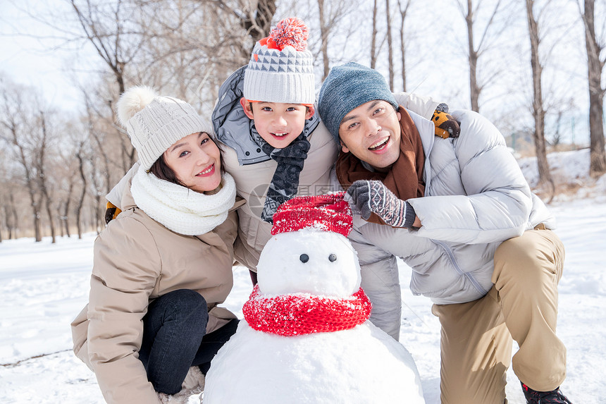 一家三口在雪地里堆雪人图片