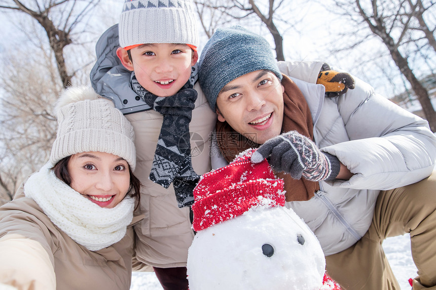 一家三口在雪地里堆雪人图片