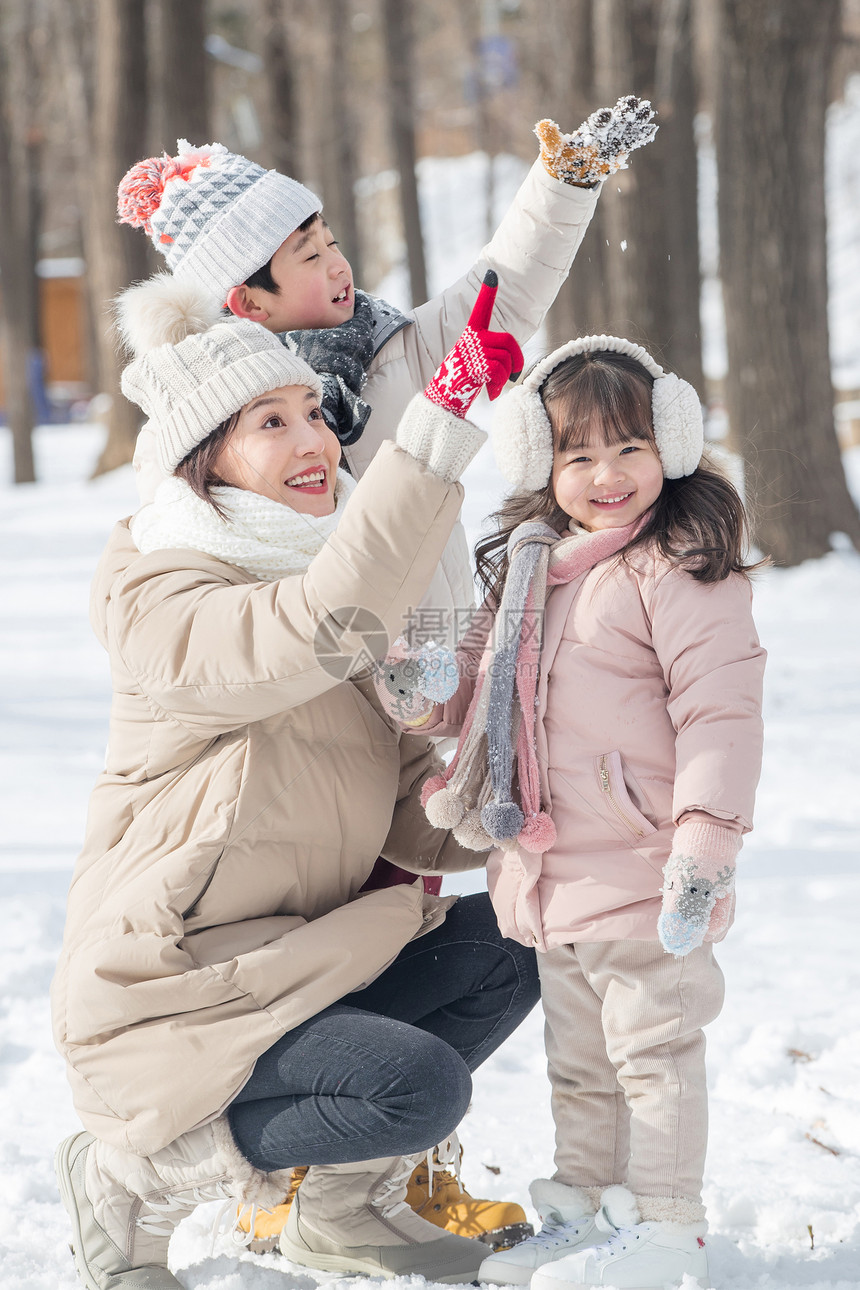 年轻妈妈和孩子们在雪地里玩耍图片