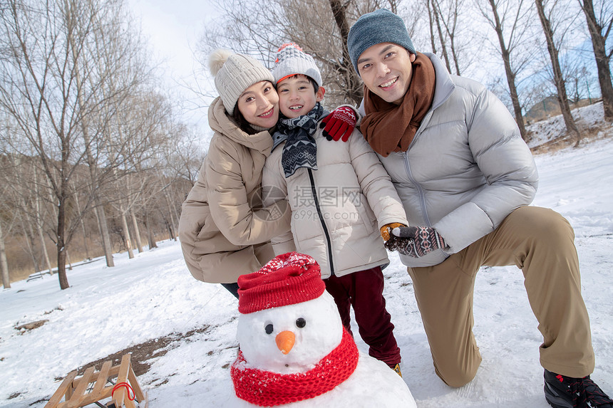 一家三口在雪地里堆雪人图片