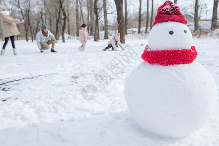 儿童打雪仗雪地里的一家人和雪人背景