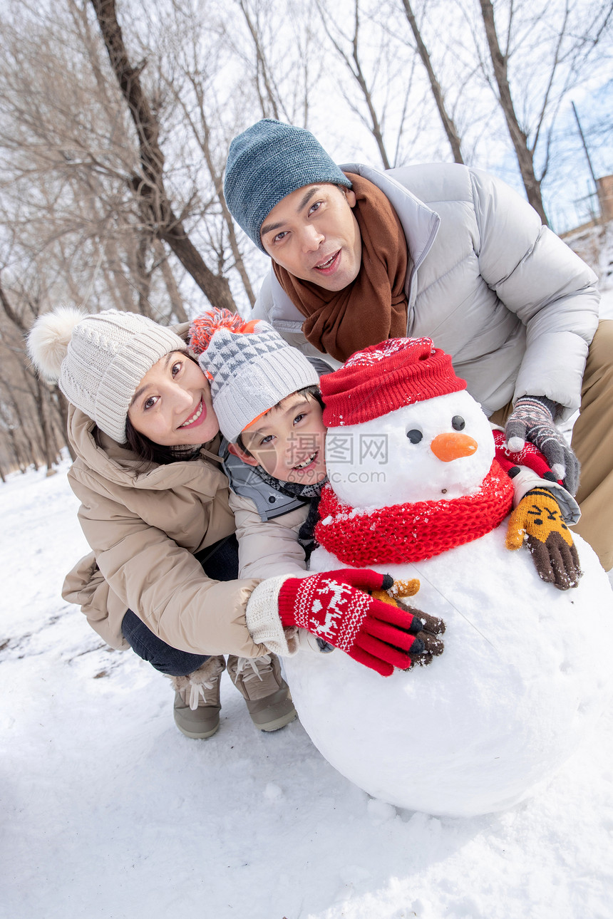 一家三口在雪地里堆雪人图片