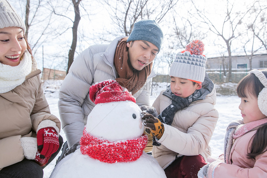 欢乐家庭在雪地里堆雪人图片