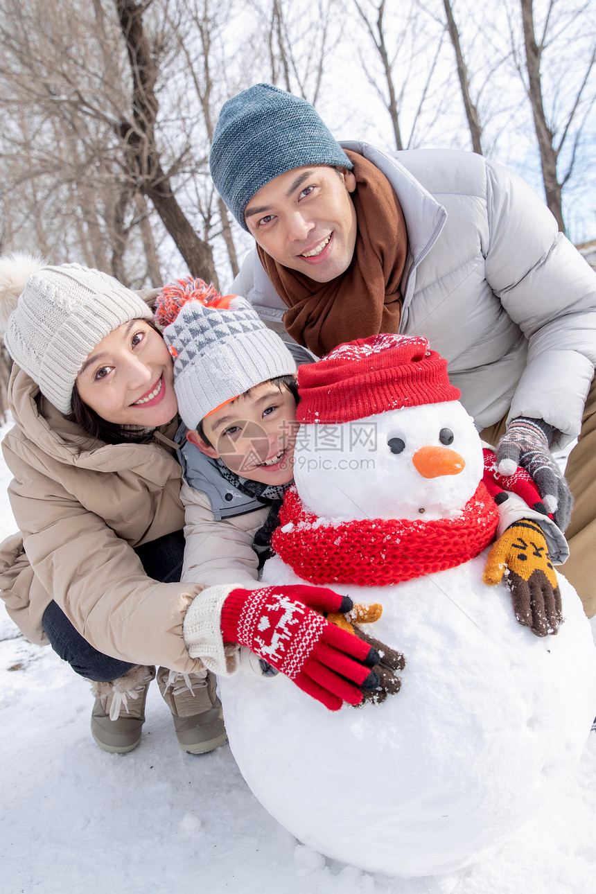 一家三口在雪地里堆雪人图片