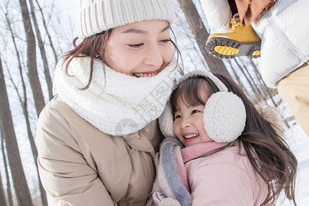 人物雪景年轻啊妈妈和女儿在雪地里玩耍背景