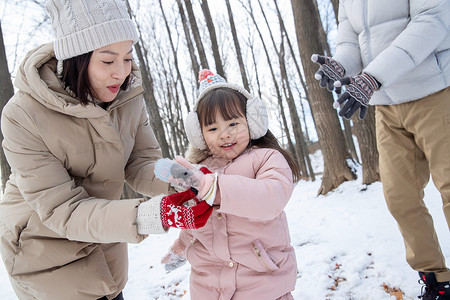 一家三口在雪地里玩耍图片