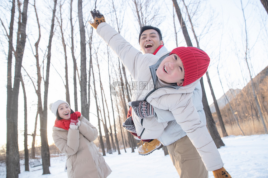 在雪地上玩耍的一家三口图片