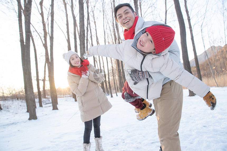 在雪地上玩耍的一家三口图片