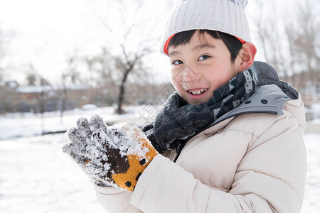 拿着雪球的人在外面玩雪的小男孩背景