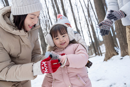 一家三口在雪地里玩耍图片