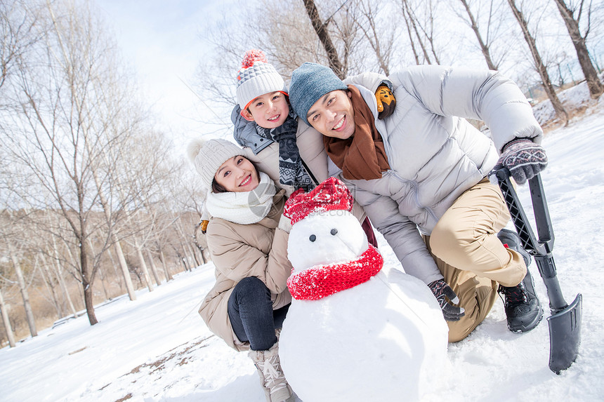 一家三口在雪地里堆雪人图片