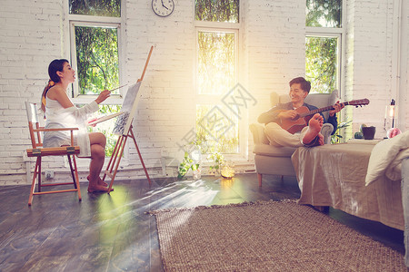 成年人画画快乐的青年伴侣在家弹吉他画画背景