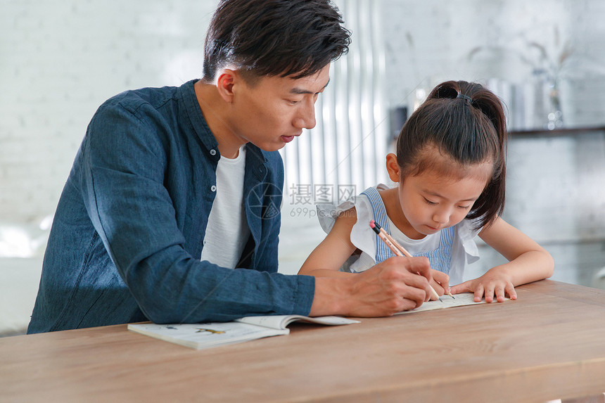 辅导女儿做作业的年轻爸爸图片