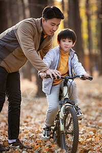郊外父亲教儿子骑自行车图片