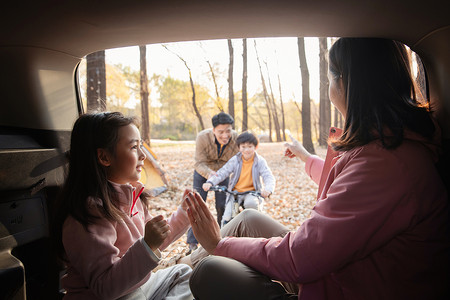 幸福母女在车中游戏快乐父子在学自行车高清图片