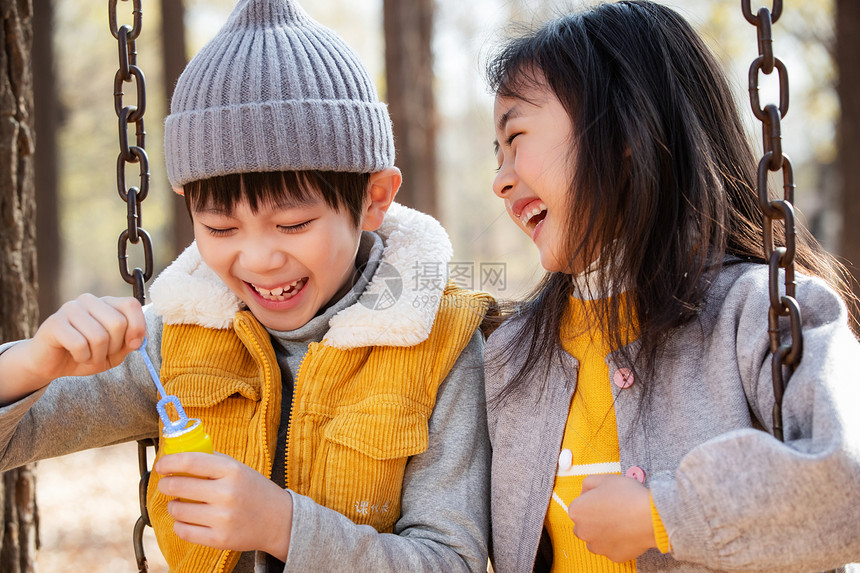 户外小女孩小男孩一起荡秋千图片