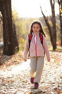 秋天户外小路上可爱的小女孩图片