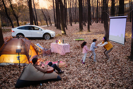 秋天傍晚幸福家庭在户外露营图片