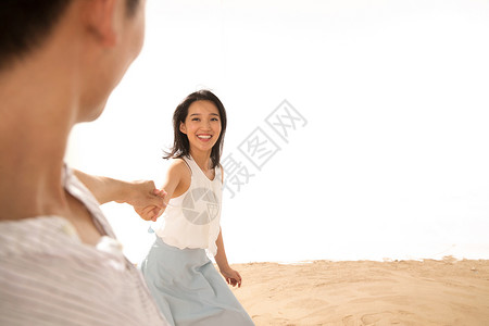 浪漫的年轻情侣在沙滩上玩耍高清图片