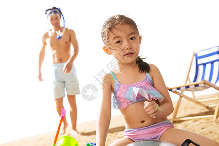 潜水镜父亲和女儿在沙滩上玩耍背景