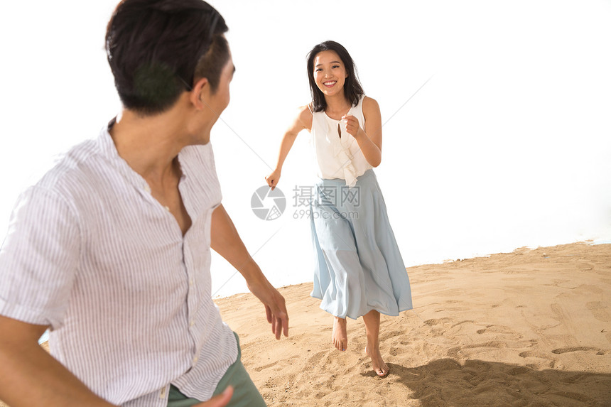 浪漫的年轻情侣在沙滩上玩耍图片