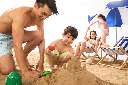 拿着铲子女孩幸福家庭在沙滩上玩耍背景