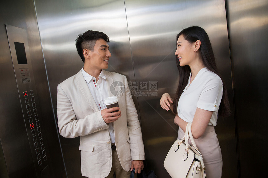 商务青年男女乘电梯图片