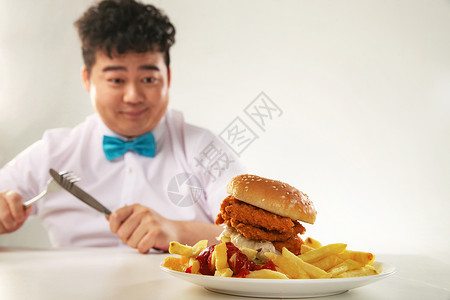 拿着叉子的男孩小胖子吃汉堡包背景