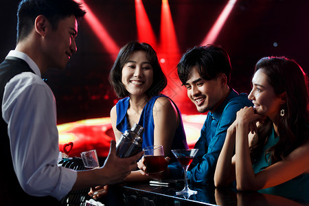 快乐的青年人在酒吧喝酒侍者高清图片素材
