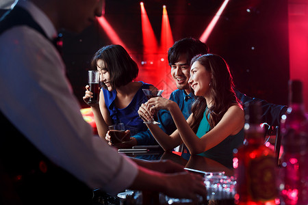 酒高脚玻璃幸福快乐的青年人在酒吧喝酒背景