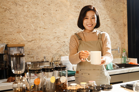 使用咖啡壶冲泡咖啡的女性咖啡店服务员背景