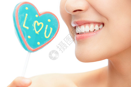 爱心牙齿心型棒棒糖和青年女人嘴部特写背景