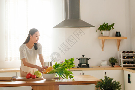 青年女人在厨房里做饭高清图片