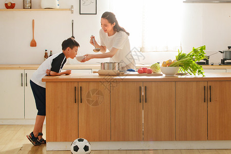 年轻妈妈和儿子在厨房高清图片