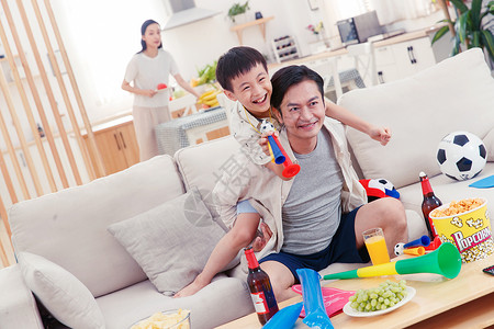 沙发上的食物和饮料父亲和儿子看体育比赛背景
