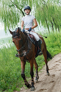 湖边小路骑马的漂亮年轻女孩图片