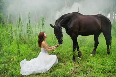 草地上穿婚纱的青年女人牵着马高清图片
