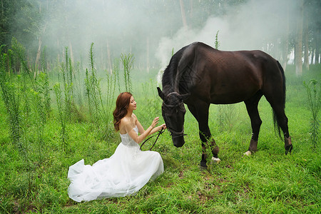 草地上穿婚纱的青年女人和马图片