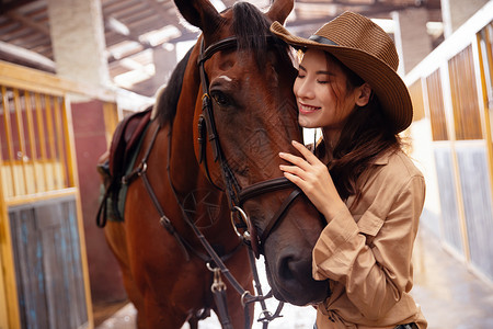 触摸阳光的女孩马厩里的青年女人和马背景