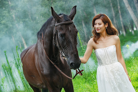 树林里漂亮的青年女人牵着马高清图片