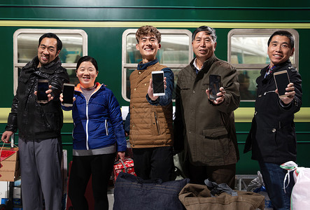 站在火车月台上展示手机的旅客高清图片